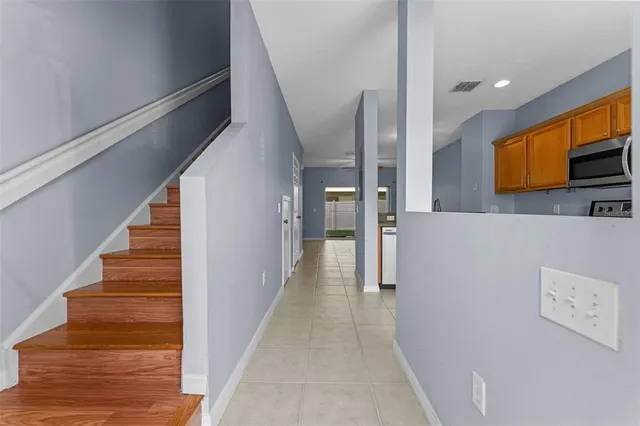 a view of a hallway with wooden floor and staircase