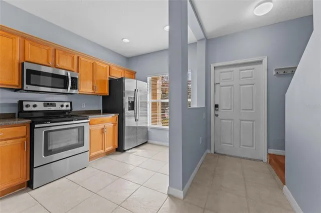 a kitchen with stainless steel appliances granite countertop a refrigerator and a stove top oven