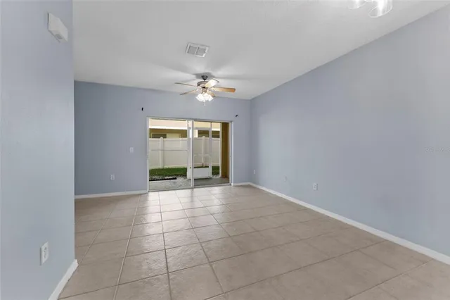a view of an empty room with a chandelier fan