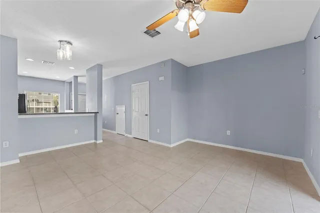 a view of an empty room with a chandelier fan