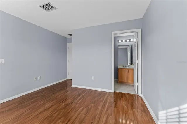a view of a room with wooden floor and a bathroom