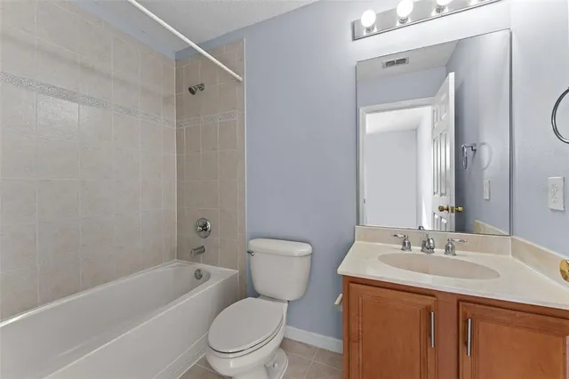 a bathroom with a granite countertop sink a toilet and shower