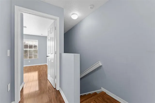 a view of a hallway with wooden floor and entryway