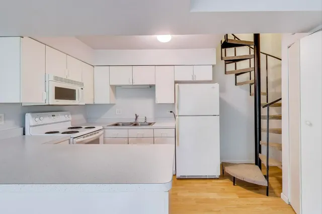a kitchen with stainless steel appliances granite countertop a refrigerator sink and white cabinets