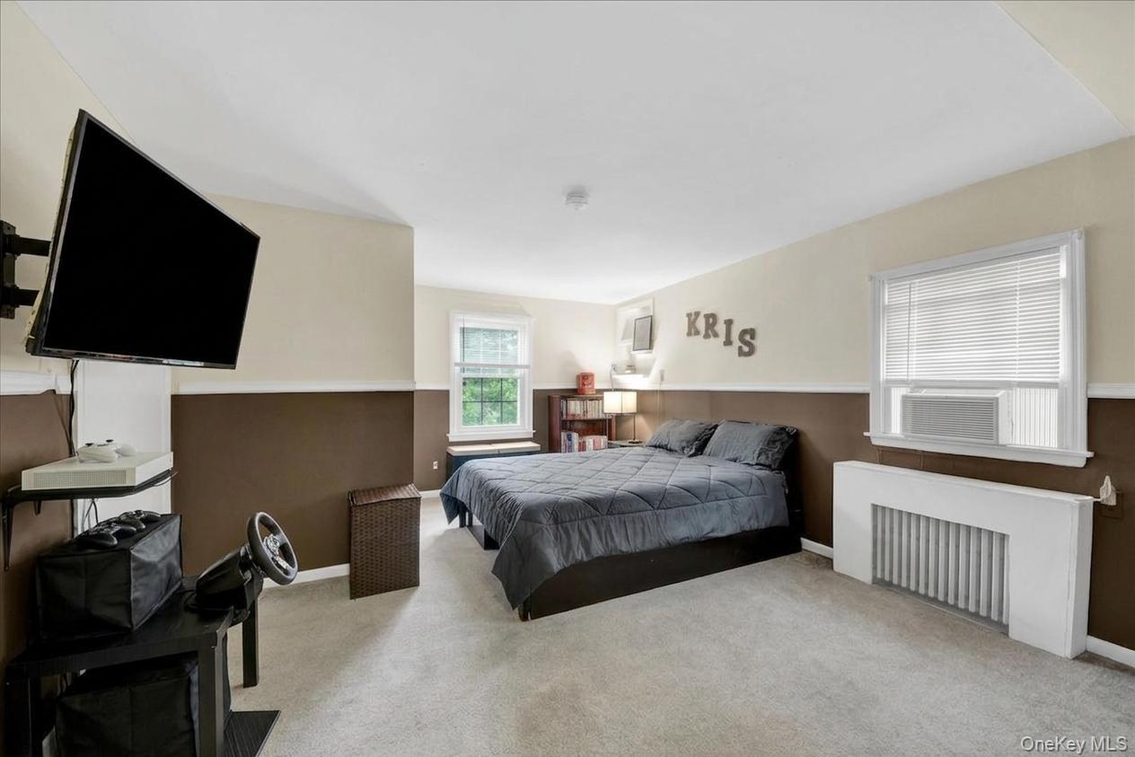 10 Susquehanna Road Ossining, NY 10562 - Photo 13 of 31 Carpeted primary bedroom featuring a built-in window air conditioning unit, white trim, and a window with blinds