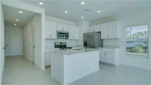 a kitchen with stainless steel appliances a refrigerator stove microwave and sink