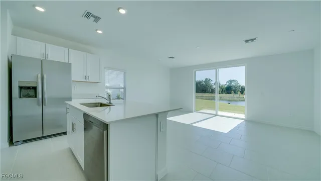 a kitchen with stainless steel appliances granite countertop a sink and a refrigerator