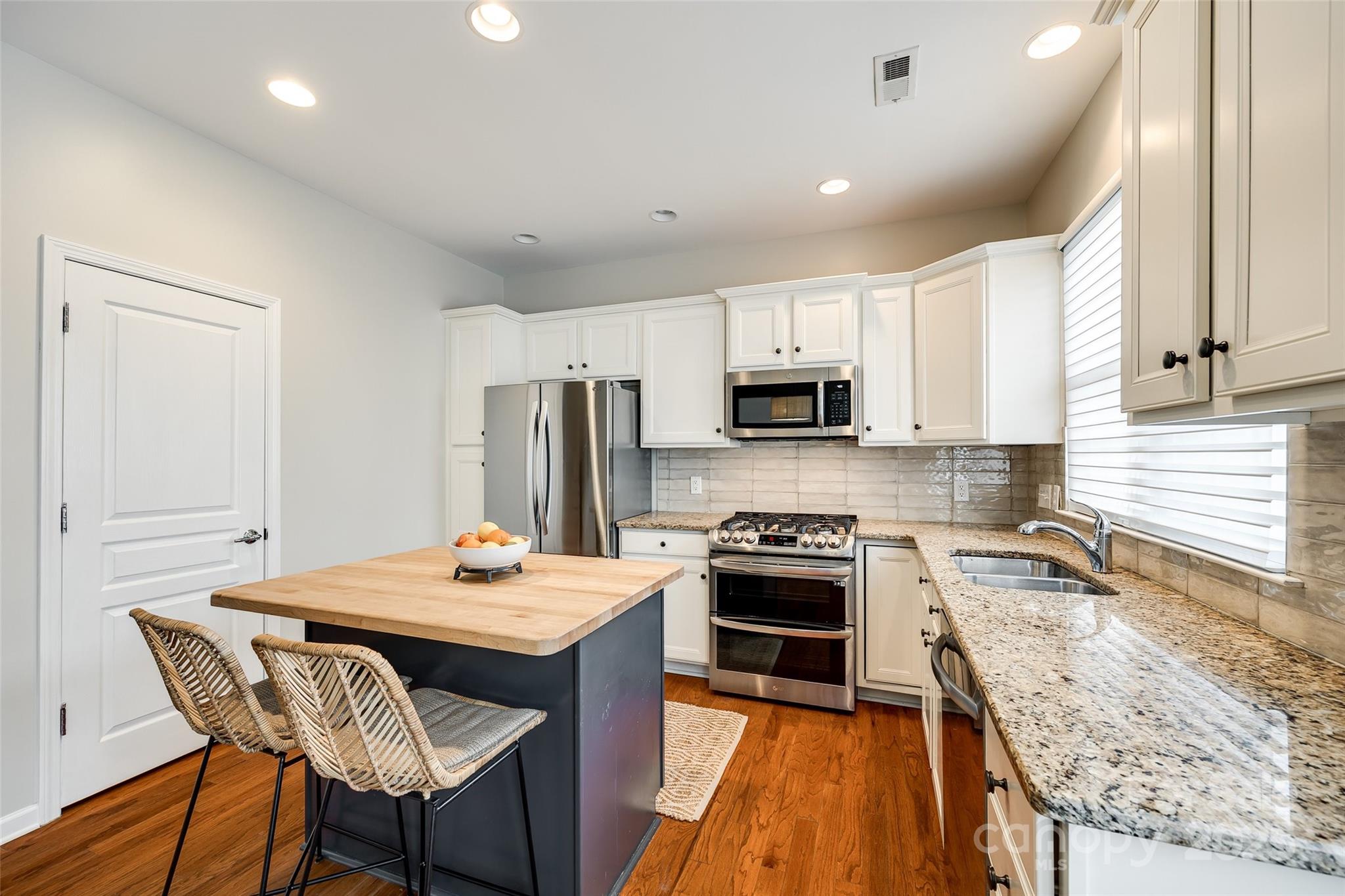 815 Granby Drive Fort Mill, SC 29708 - Photo 12 of 30 a kitchen with stainless steel appliances granite countertop a stove top oven a sink dishwasher and a refrigerator with wooden floor