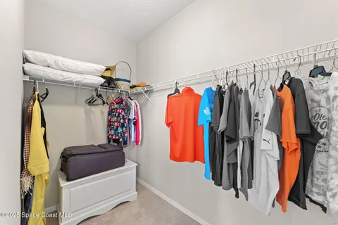 a view of walk in closet with clothes