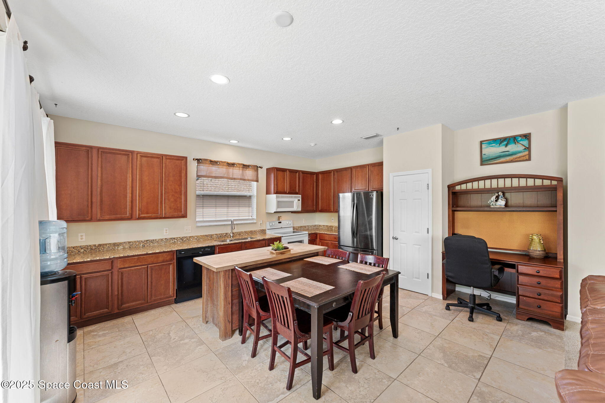 1266 Ragen Road Southeast Palm Bay, FL 32909 - Photo 8 of 28 a kitchen with stainless steel appliances granite countertop table chairs sink and cabinets