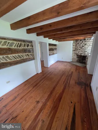 a view of empty room with wooden floor and staircase