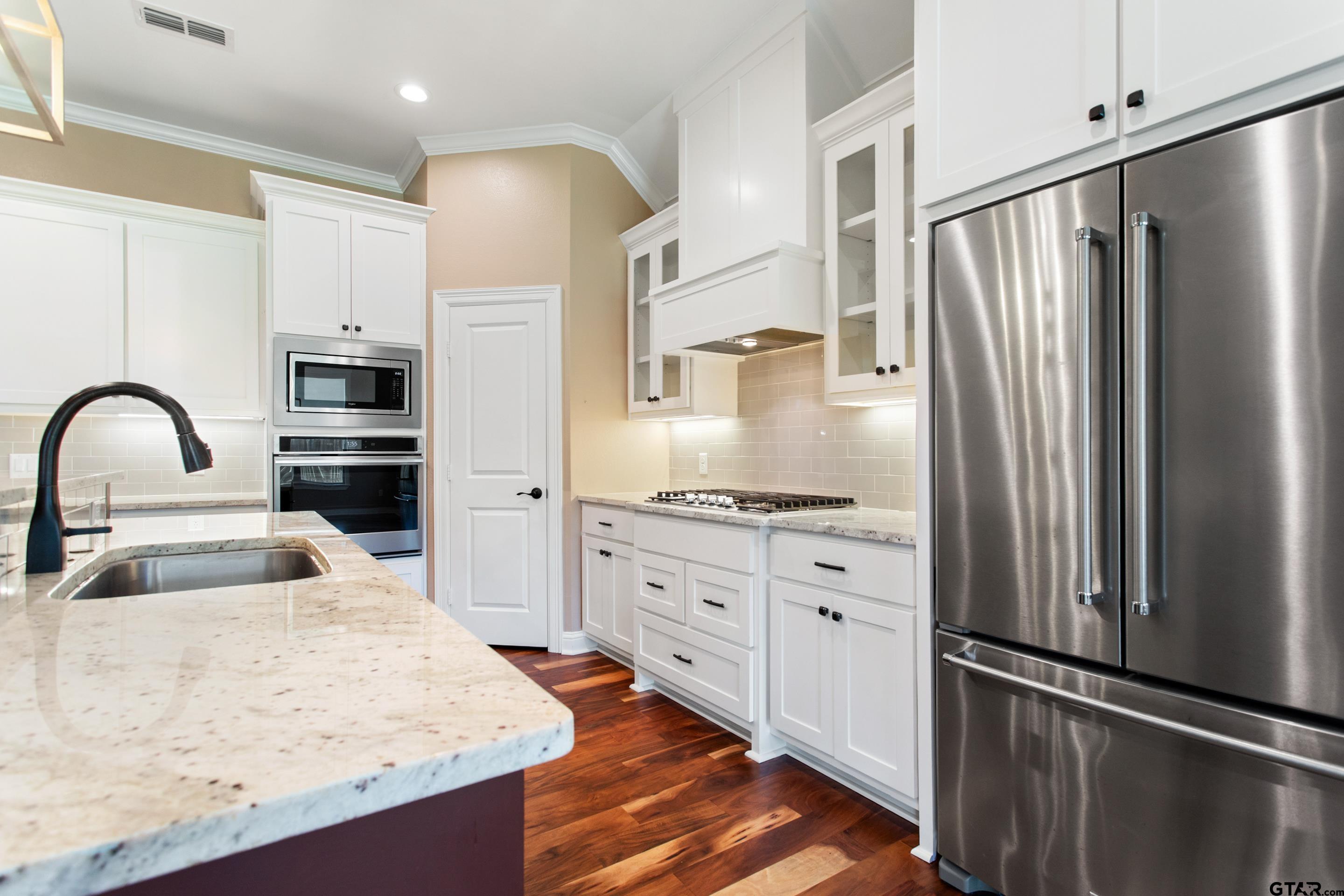 105 Nathan Road Chandler, TX 75758 - Photo 7 of 36 a kitchen with granite countertop a refrigerator oven a sink and cabinets