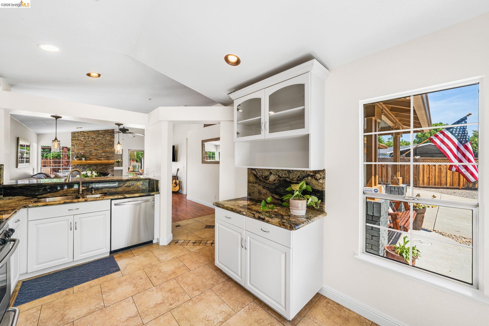 1186 El Rio Court Livermore, CA 94551 - Photo 15 of 60 Kitchen featuring white cabinetry, granite countertops, tile flooring, stainless steel dishwasher, and recessed lighting