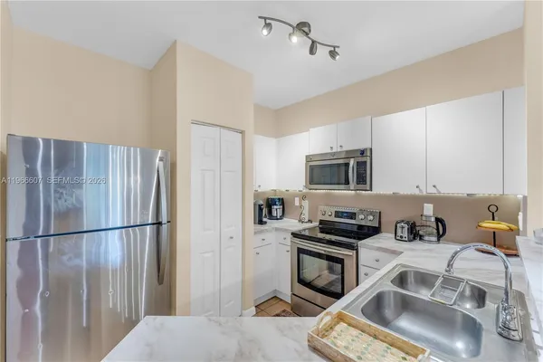 a kitchen with a refrigerator a stove a microwave and cabinets