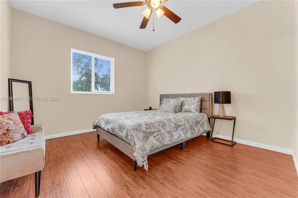 a bedroom with a bed and wooden floor