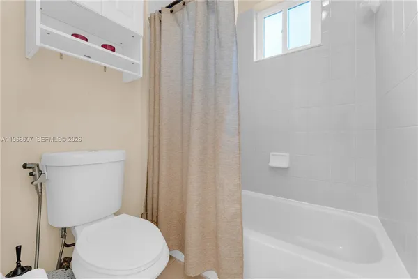 a white toilet sitting next to a bath tub