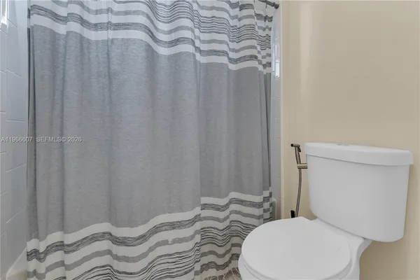 a bathroom with a toilet and a shower curtain