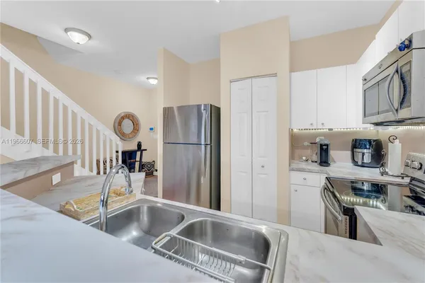 a kitchen with stainless steel appliances granite countertop a refrigerator and a sink