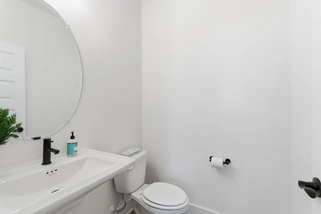 a bathroom with a sink toilet and a mirror