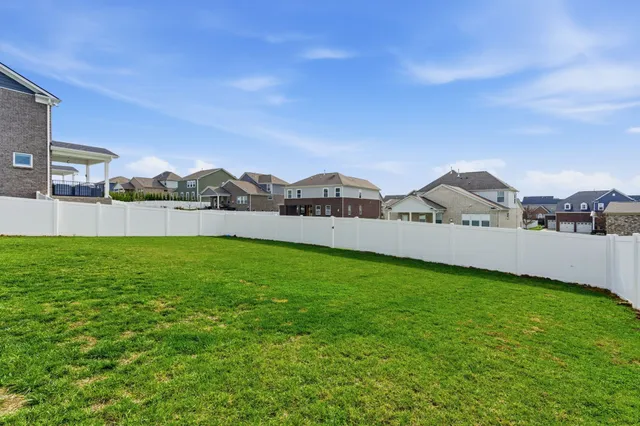 a view of a house with a big yard and large trees