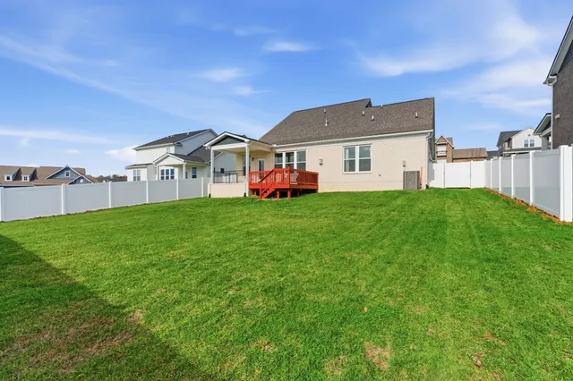 a view of a green field with houses in the background