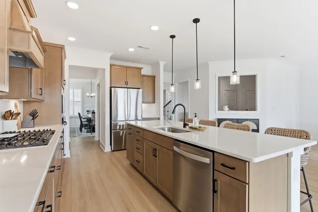 a kitchen with stainless steel appliances a sink stove and refrigerator