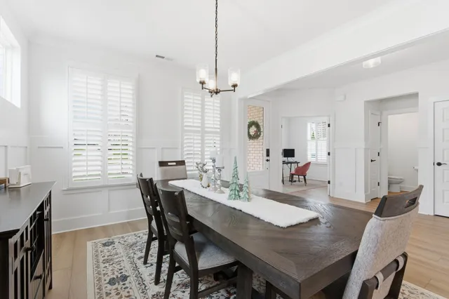a view of a a dining room with furniture window and wooden floor