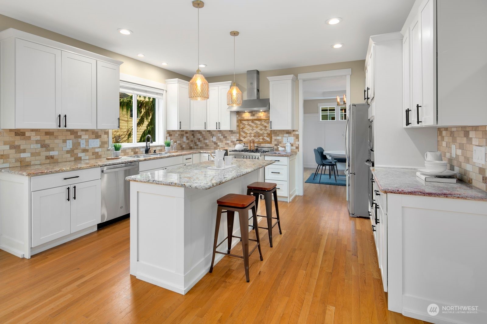 3616 Northeast 65th Street Seattle, WA 98115 - Photo 5 of 40 a kitchen with stainless steel appliances granite countertop wooden floor sink and cabinets