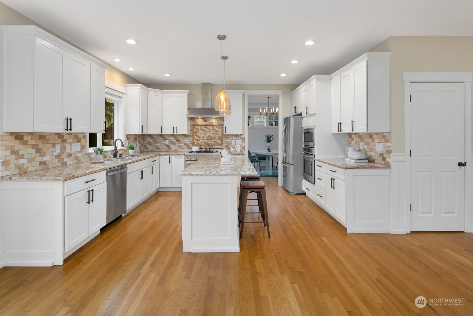 3616 Northeast 65th Street Seattle, WA 98115 - Photo 6 of 40 a large kitchen with stainless steel appliances kitchen island a large counter top and a stove top oven