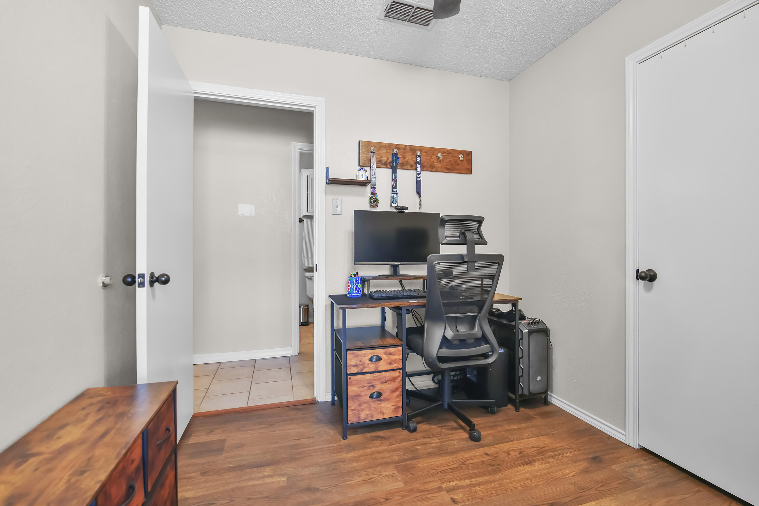 2216 86th Street Lubbock, TX 79423 - Photo 18 of 36 a view of a workspace with furniture and wooden floor