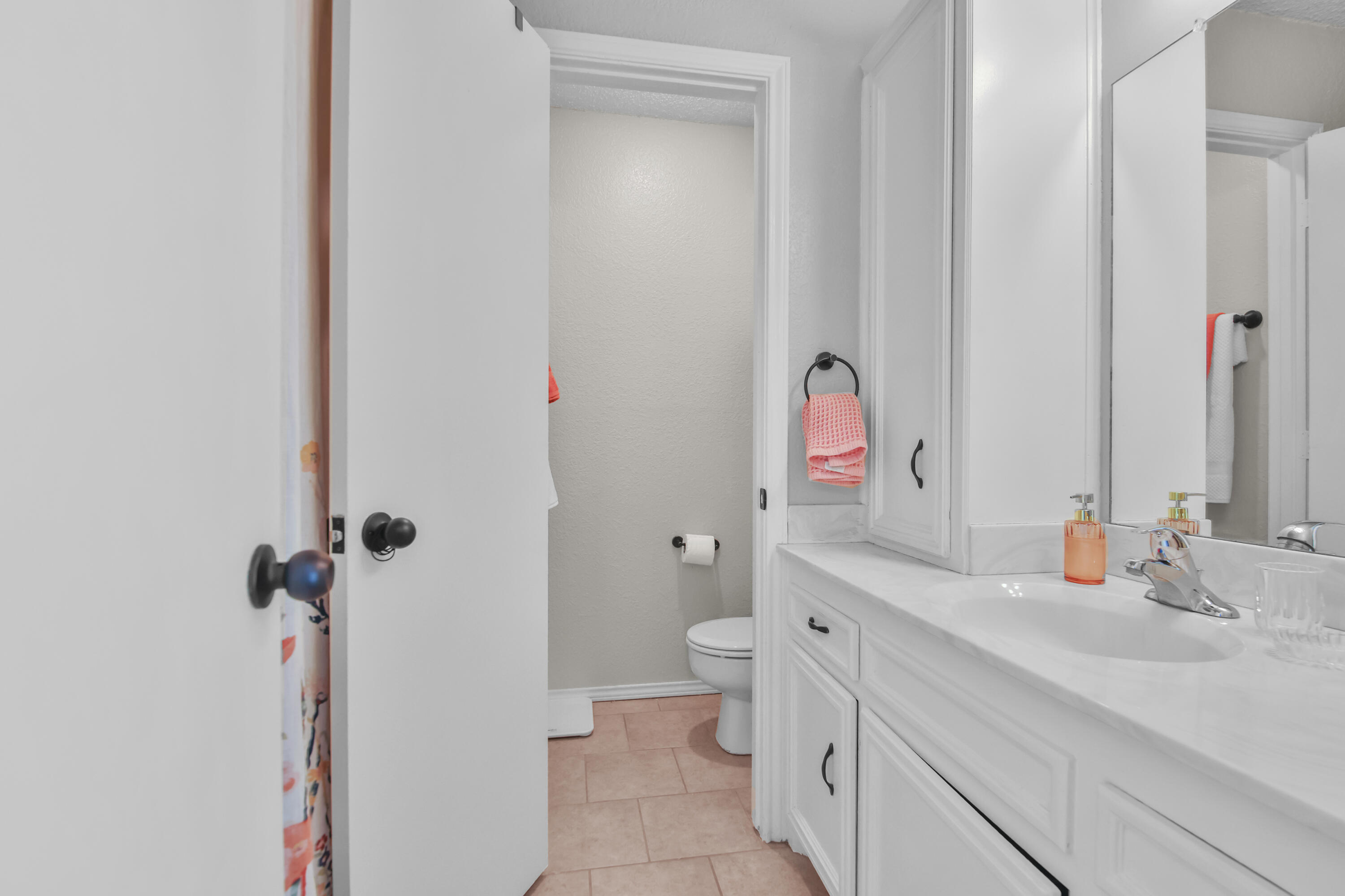2216 86th Street Lubbock, TX 79423 - Photo 23 of 36 a bathroom with a sink and mirror with toilet