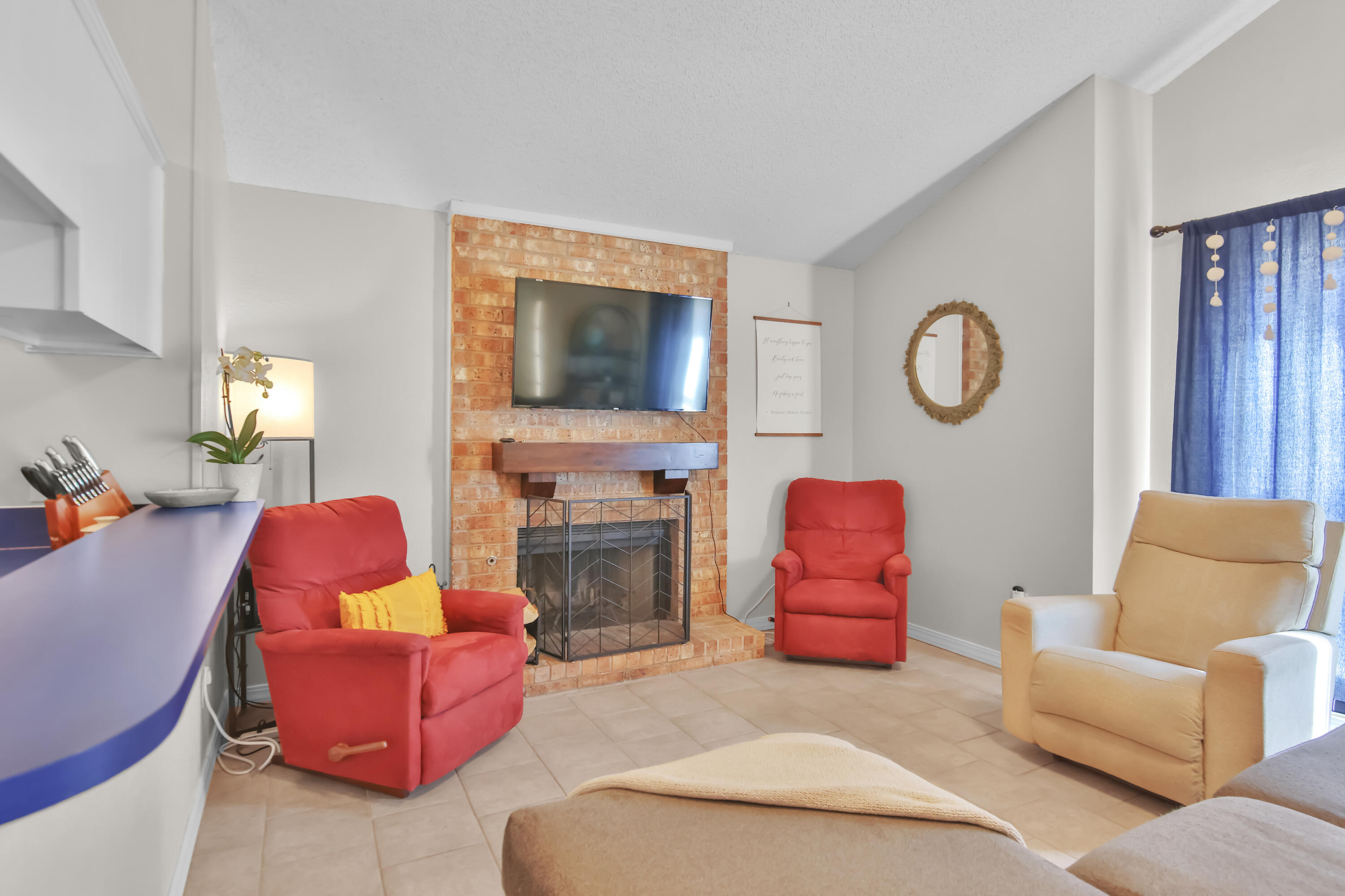 2216 86th Street Lubbock, TX 79423 - Photo 7 of 36 a living room with furniture a fireplace and a flat screen tv