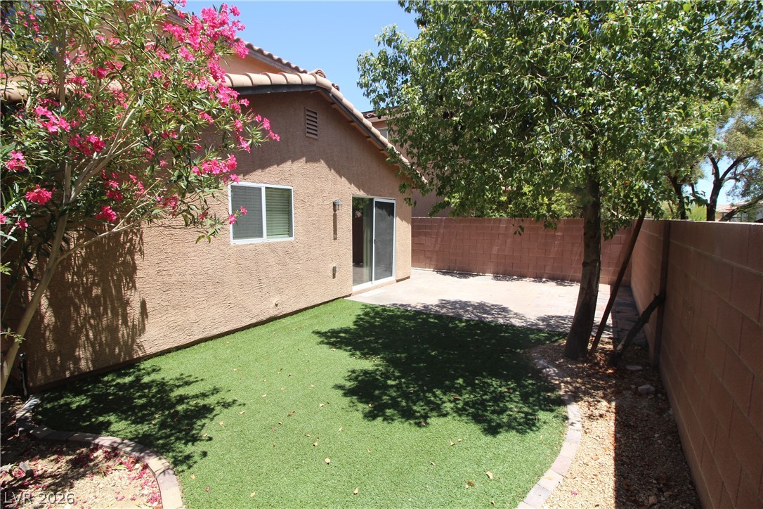9289 Valley Ranch Avenue Las Vegas, NV 89178 - Photo 29 of 29 An inviting backyard with a low-maintenance artificial lawn, mature trees, and a spacious concrete patio.