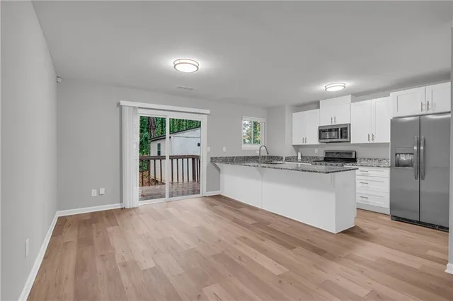 a kitchen with a refrigerator and white cabinets