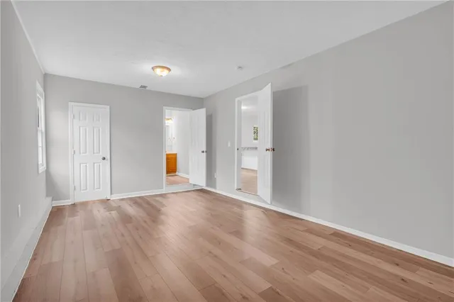 a view of empty room with wooden floor and windows