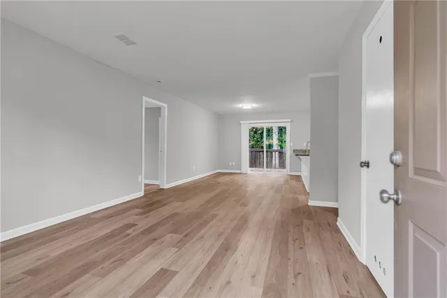 a view of a big room with wooden floor and windows