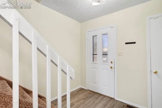 a view of a hallway with wooden floor and entryway