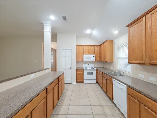 a large kitchen with stainless steel appliances granite countertop a sink and cabinets