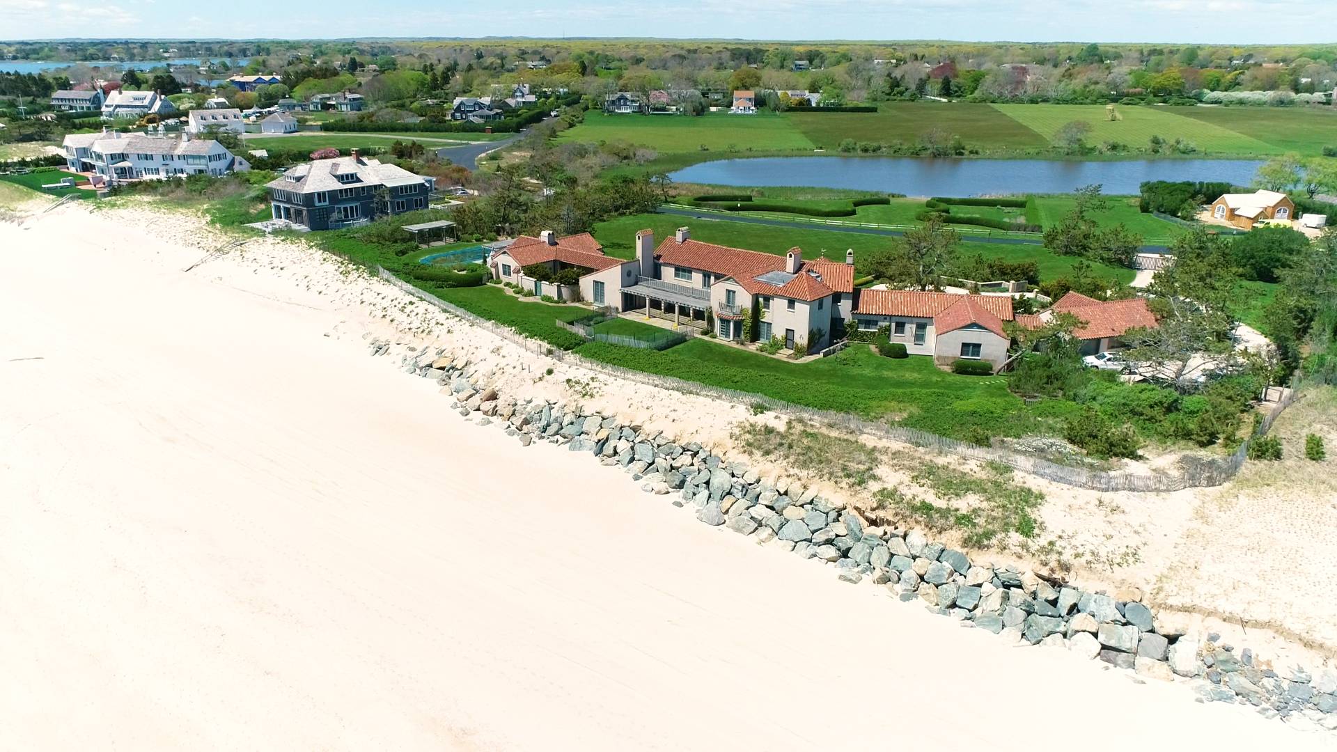 an aerial view of a house with a garden and lake view