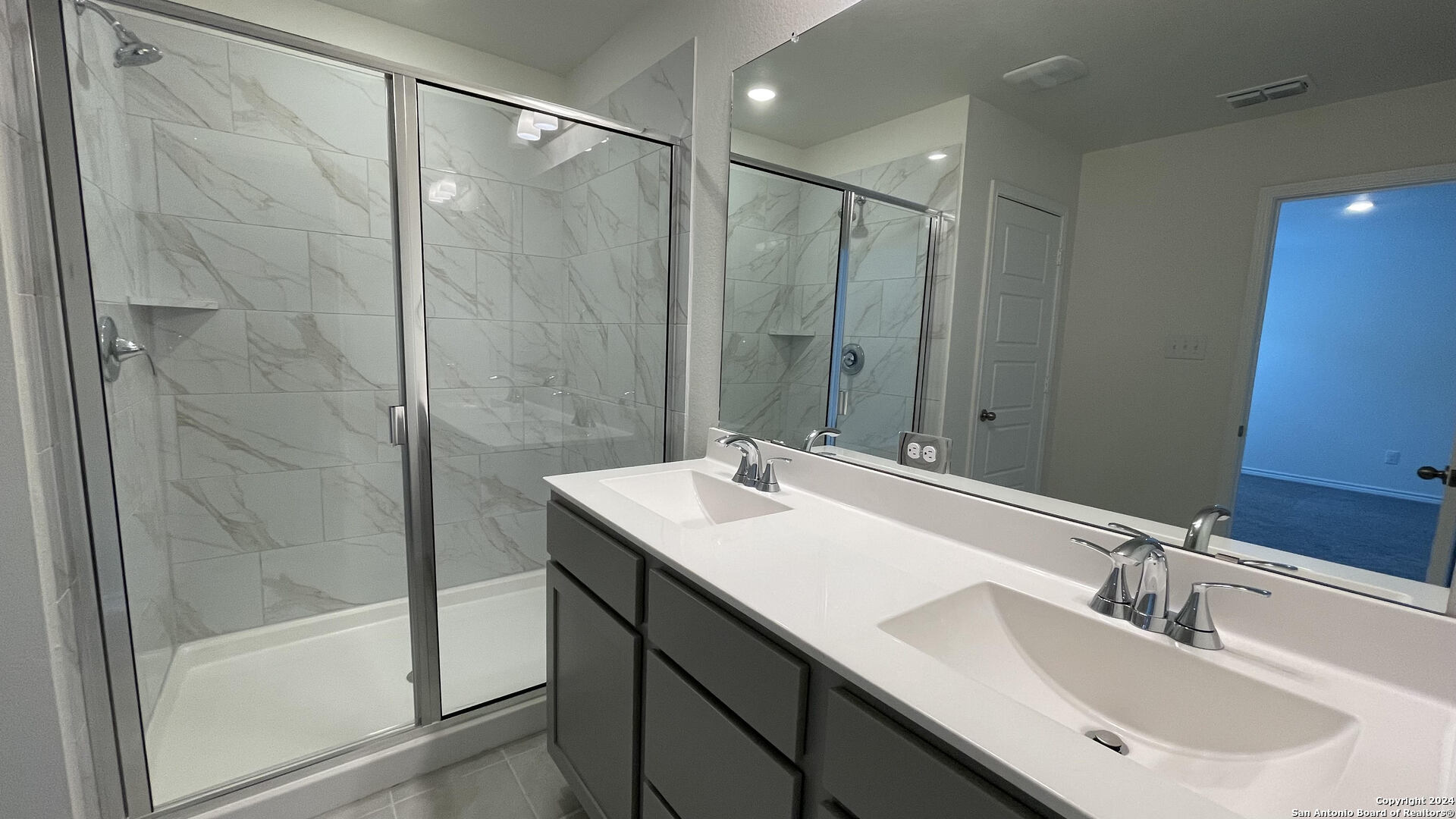 14839 Vance Jackson Road, Unit 606 San Antonio, TX 78249 - Photo 12 of 13 a bathroom with a sink double vanity mirror and a shower