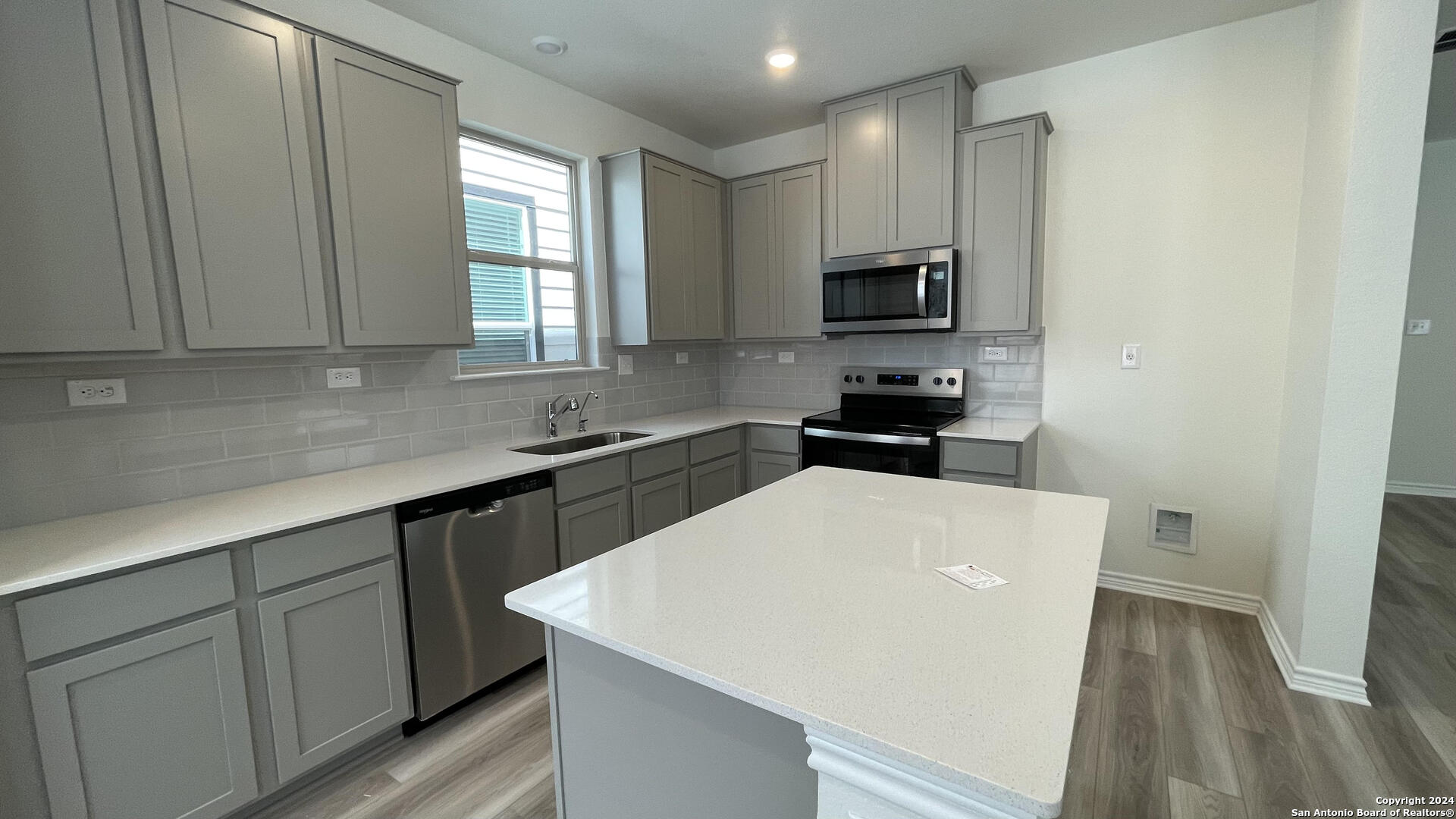 14839 Vance Jackson Road, Unit 606 San Antonio, TX 78249 - Photo 4 of 13 a kitchen with a sink a microwave a stove and refrigerator