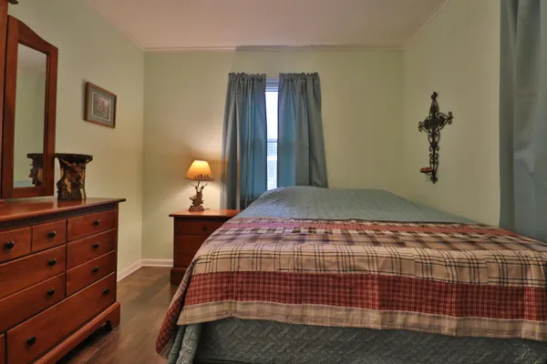 a bedroom with a bed and dresser with mirror