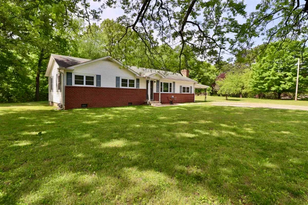 a view of backyard of house with green space