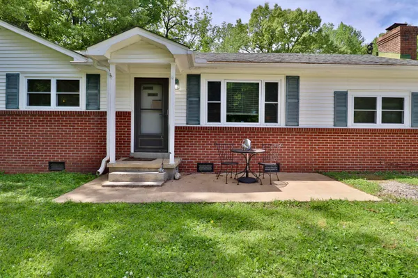 a backyard of a house with table and chairs