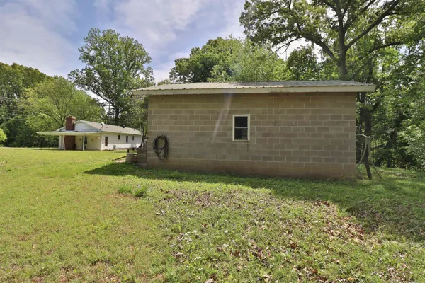 a front view of a house with a yard and trees