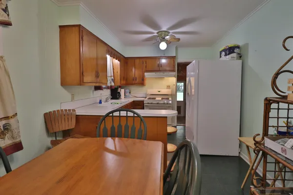 a kitchen with a table chairs refrigerator and cabinets