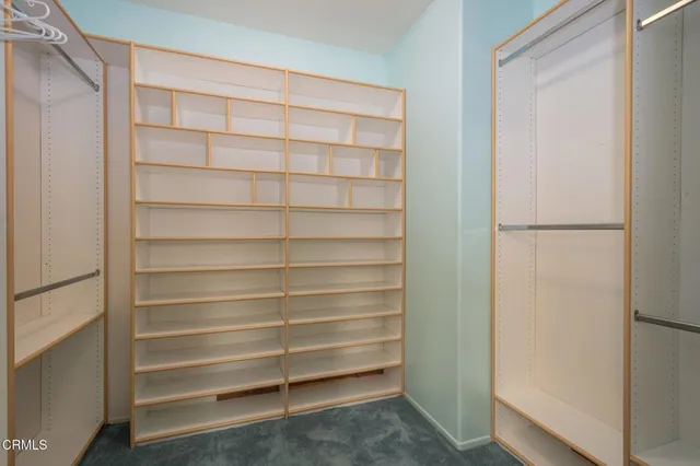 a view of walk in closet with empty racks