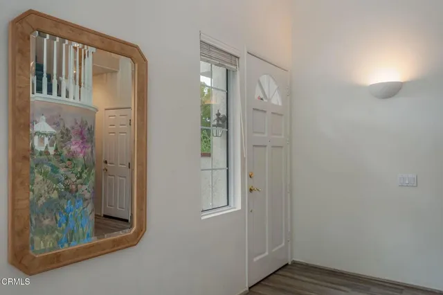 hallway with view of wooden floor and cabinet