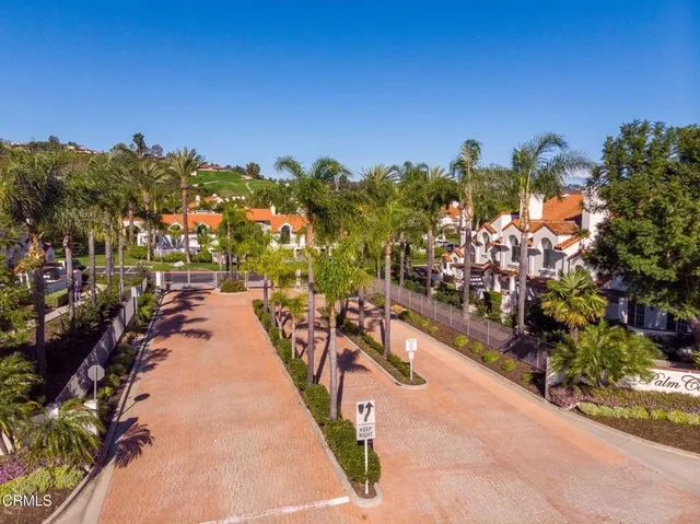an aerial view of a tennis ground and a cars park side of the road