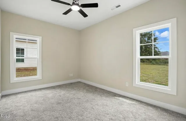an empty room with a window and a ceiling fan